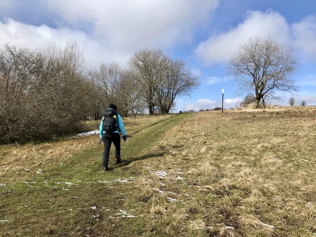 Die Wanderung geht bergauf. Im Hintergrund ist die Antenne des Heidelsteins zu sehen.