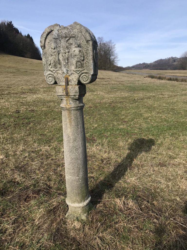 Mitten auf der Wiese steht ein steinerner Bildstock