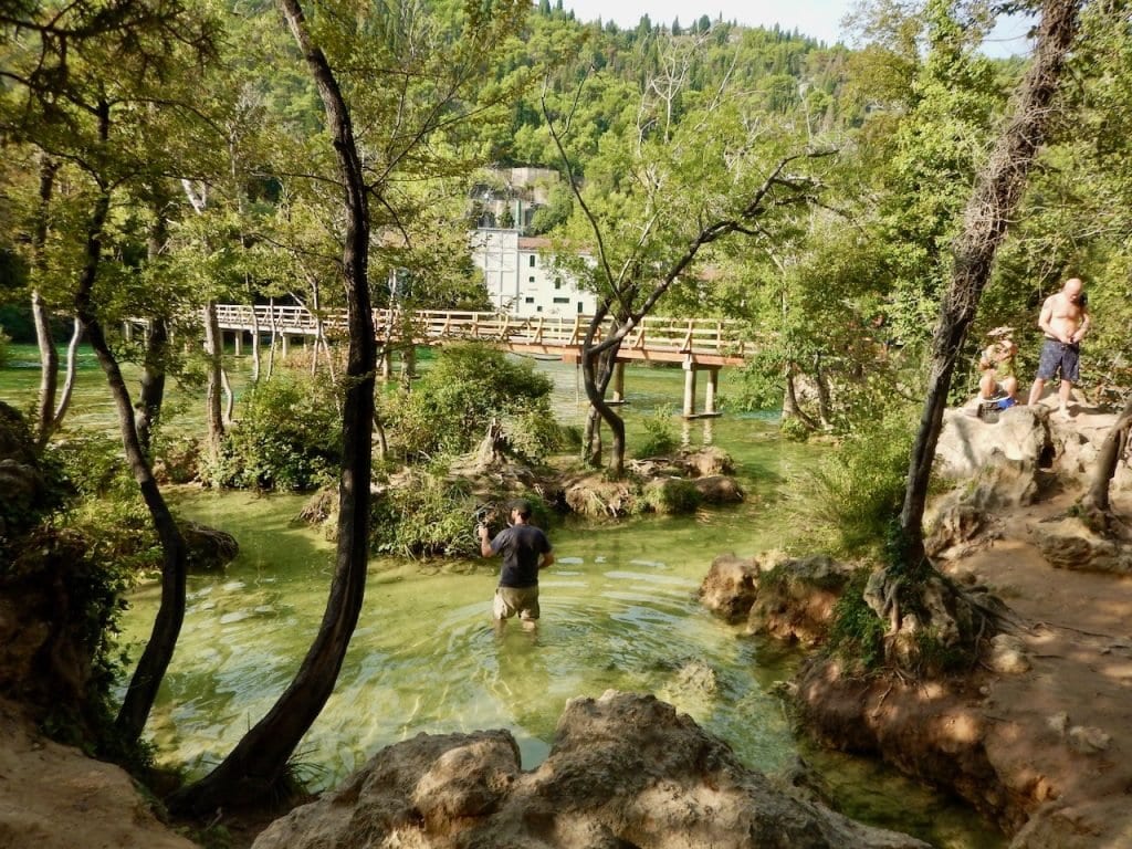 Ich warte durch das kristallklare Wasser des Skradinski Buk und Filme kleine Fische